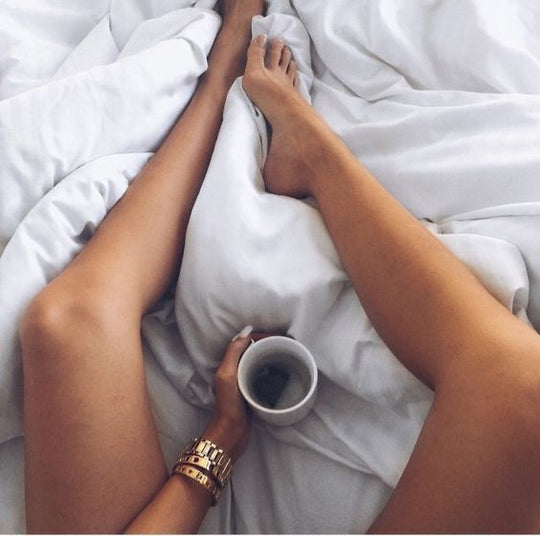 Frau mit Kaffee im Bett mit Eukalyptus Bettwäsche